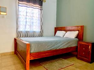 a small bed in a room with a window at Zen villa in Old Yundum