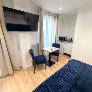 a bedroom with a bed and a table and chairs at Aux Charmes - Suites Prestige et Petit Déjeuner en chambre - Cote d Opale in Isques