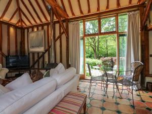 a living room with a white couch and a tv at Petworth Barn in Petworth