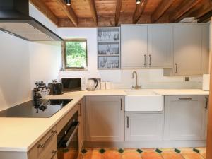 a kitchen with white cabinets and a sink at Petworth Barn in Petworth