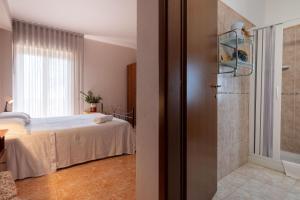 a bedroom with a bed and a walk in shower at Hotel Ristorante L'Orizzonte in Le Castella +11 photos
