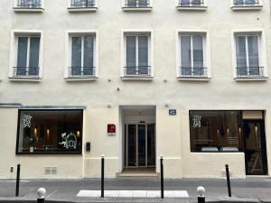 a white building with windows and doors on a street at Seb & Co in Paris