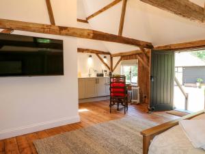 a living room with a large flat screen tv at The Granary in Petworth