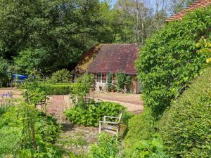 a garden with a bench in front of a house at The Granary in Petworth