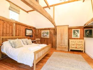 a bedroom with a bed in a room with wooden walls at The Granary in Petworth +14 photos