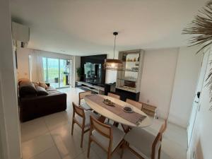 a living room with a table and chairs and a couch at Apartamento - Resort Golf Ville in Aquiraz