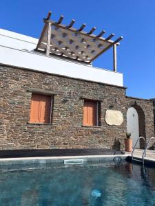 a house with a swimming pool in front of a building at Imarkellis Tinos Boutique Villas in Panormos