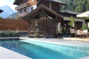 a house with a swimming pool in front of a house at Fleur des Neiges in Morzine +34 photos