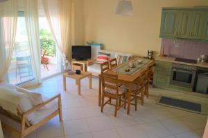 a kitchen with green cabinets and a table and chairs at EFFIE'S VACATION by the sea in Kanali