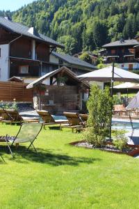 a group of chairs sitting in the grass near a pool at Fleur des Neiges in Morzine