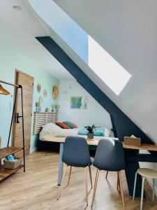 a bedroom with a bed and two chairs at Entre Terre & Sel in Clohars-Carnoët