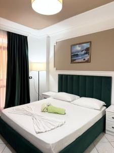 a bedroom with a large bed with a green headboard at Bamisa Apartments in Golem