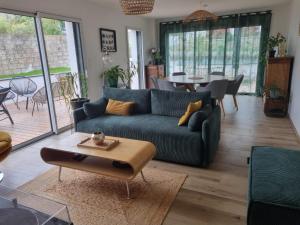 a living room with a blue couch and a table at Les Ganivelles in Belz