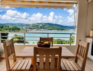a dining room table with a view of the water at STUDIO HORIZON VUE MER in La Trinité