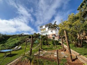 a house on top of a hill with a playground at Villa Alta Vista in São Jorge