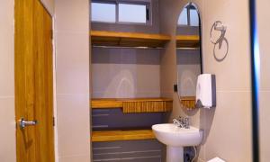 ein Badezimmer mit Waschbecken und Spiegel in der Unterkunft Zumo hotel lorica in Lorica