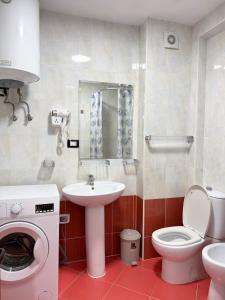 a bathroom with a sink toilet and a washing machine at Bamisa Apartments in Golem +43 photos