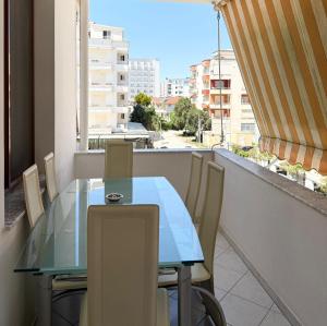 a glass table and chairs on a balcony with a view at Bamisa Apartments in Golem