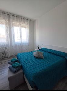 a bedroom with a large bed with a blue comforter at Sweet home in Novara