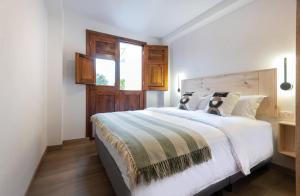 a bedroom with a large white bed with a window at Amaru Suites Salento - Apartamentos con Jacuzzi y Vistas al Bosque in Salento +43 photos
