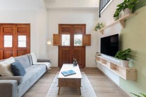 a living room with a couch and a tv at Amaru Suites Salento - Apartamentos con Jacuzzi y Vistas al Bosque in Salento