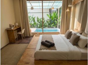 a bedroom with a large bed with a large window at Thara Pearl Villa in Ko Phangan +2 photos