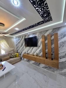 a living room with a tv on a stone wall at pacotanjawi achakar in Tangier
