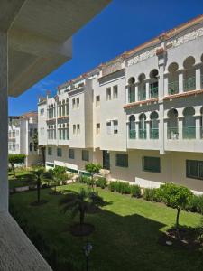 a large white building with trees in a courtyard at pacotanjawi achakar in Tangier