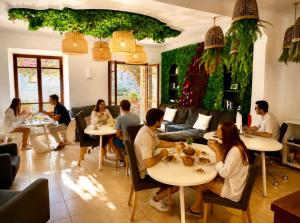 a group of people sitting at tables in a restaurant at Primavera House Port Sóller formerly Sol Port Sóller in Port de Soller
