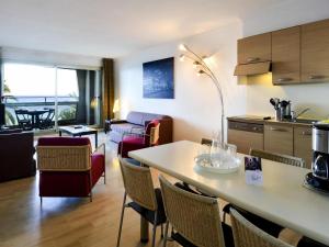 a kitchen and living room with a table and chairs at Aparthotel Adagio Nice Promenade des Anglais in Nice