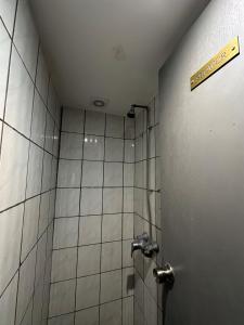 a bathroom with a shower with a sign on the wall at 18 Budget Inn in London