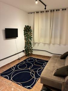 a living room with a couch and a tv at Apartamento em Petrópolis 1 quarto completo in Petrópolis