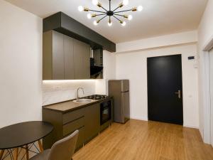 a kitchen with a table and a black refrigerator at Thela Apartment in Telavi