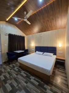 a bedroom with a bed and a ceiling fan at Serene River Cottages Sadhupul in Jūnga