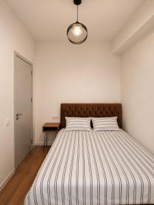 a bedroom with a large bed with a brown headboard at Thela Apartment in Telavi