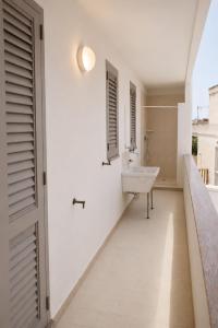 a white bathroom with a sink and a window at Poésia in San Foca +53 photos