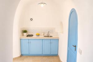a blue kitchen with a sink and a blue door at Maridea - Il Paradiso sulla Baia in Ponza +67 photos