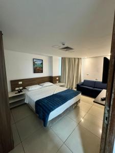 a bedroom with a large bed and a couch at Praiano Flat Tambaú in João Pessoa +40 photos