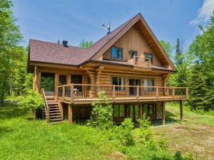 a large wooden house with a large deck at Rustic Chalet & Serenity in Mont Blanc in Saint-Faustin