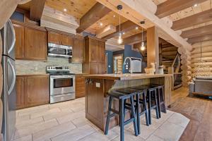 a kitchen with wooden cabinets and a island with bar stools at Rustic Chalet & Serenity in Mont Blanc in Saint-Faustin