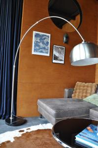 a floor lamp in a living room with a couch at PARO cabin in Ignalina