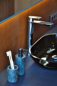 a bathroom counter with a sink and toothbrushes at PARO cabin in Ignalina +47 photos