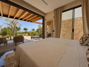 a bedroom with a bed and a large window at Can Skye in Sant Carles de Peralta