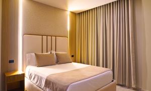 ein Schlafzimmer mit einem Bett und einem Fenster mit Vorhängen in der Unterkunft Zumo hotel lorica in Lorica