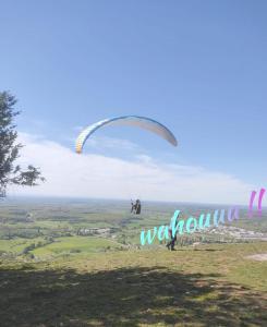 a person flying a parachute on top of a hill at Au jeu de mots, chambre d'hôtes proche Poligny in Barretaine