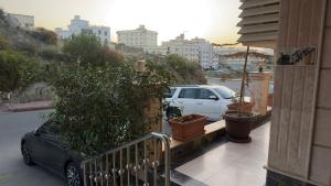 a car parked on the side of a building with plants at Zahraa Al-Tal in Baljurashi