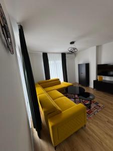 a living room with a yellow couch and a table at Villa Sunny Alley - Sunčani Sokak in Sarajevo +20 photos