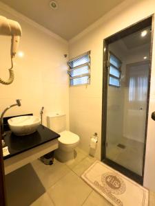 a bathroom with a toilet and a sink and a shower at Saionara Hotel in Rio de Janeiro +59 photos