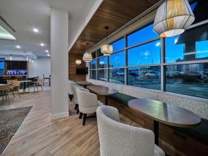 a restaurant with tables and chairs and windows at SpringHill Suites by Marriott Phoenix Gilbert in Gilbert