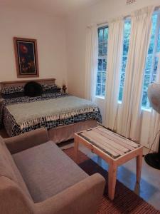 a bedroom with a bed and a couch and windows at Good Vibes in Uniondale